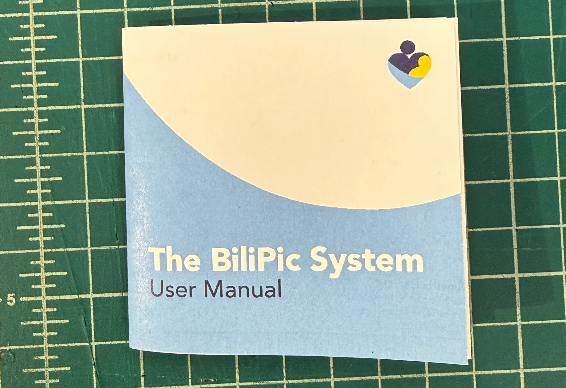 The printed reader 'User Manual' booklet — a square cover with the same curved-horizon artwork and the Bilimetrix mark, set in the brand's blue and cream.